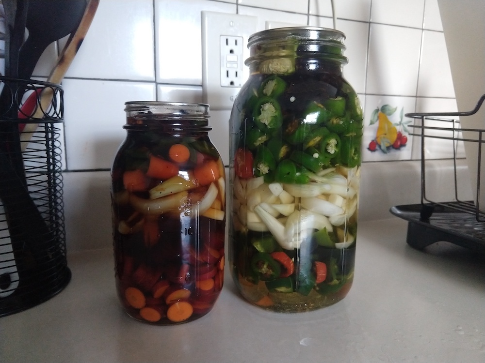 A good portion of my garden harvest fermenting in glass jars.