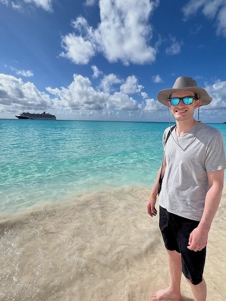 A photo me on a beach in the Bahamas with with our ship in the background