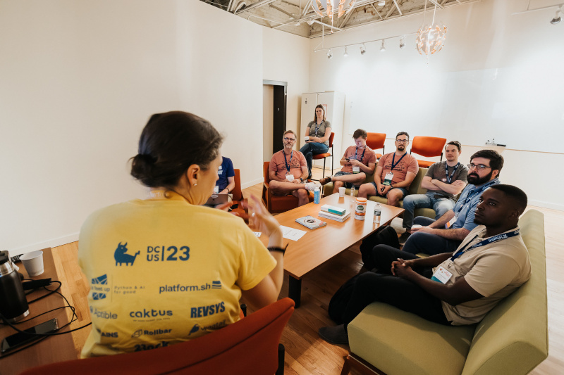 Several people learning how Natalia manages Trac, Django' ticket tracker at DjangoCon 2023.<br />Credit: <a href="https://bartpawlik.format.com/">Bartek Pawlik</a>