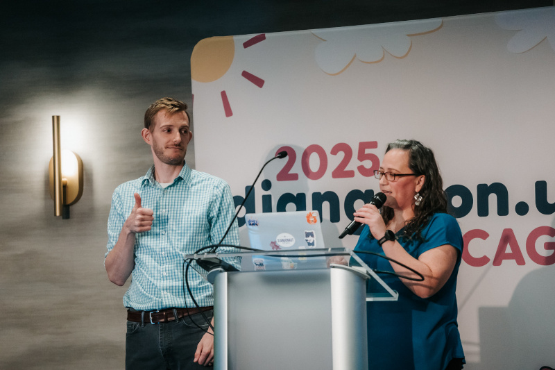 A photo of me and Rachell Calhoun on stage DjangoCon US 2025. You can't tell I'm nervous at all! <br />Credit: <a href="https://bartpawlik.format.com/">Bartek Pawlik</a>
